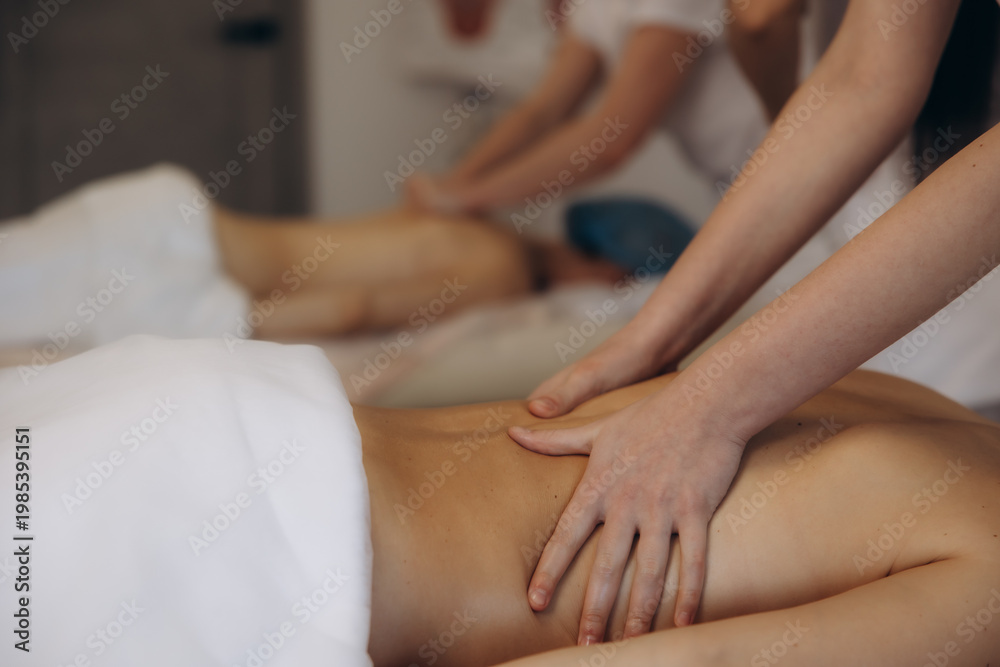 Fototapeta premium People receiving back massage during wellness therapy session