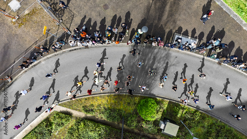 Foto Aerial drone view of people running half marathon race in city, shadows of runne