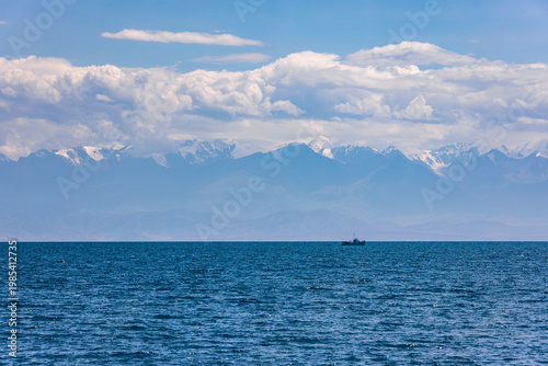 Boat sailing on serene water with mountains in background