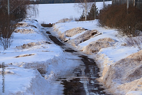 Early spring in a Russian village, rural road, spring thaw