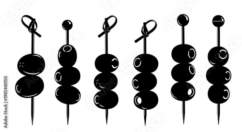 A set of black olives on skewers against a white background