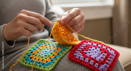 Crocheting Hands Working with Colorful Granny Squares and Wool Yarn