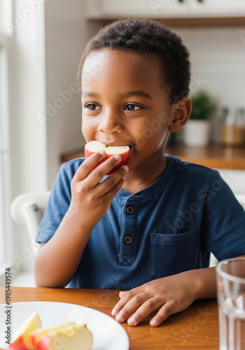 African American child eating fruit at table with smile  