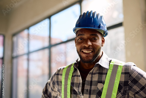 Schilderij op canvas Portrait of happy black worker at construction site looking at camera