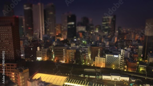 新宿のビル群と行き交う電車の夜景と朝から昼のミニチュア風景