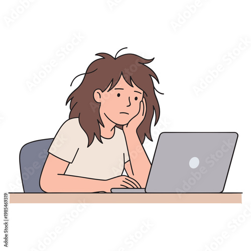 A woman sits at a desk looking stressed while using a laptop computer