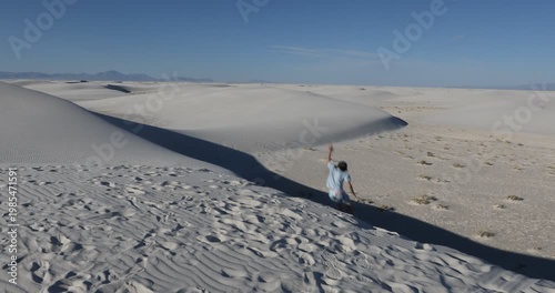 child leaping down sand dunes, White Sands National Park, NM