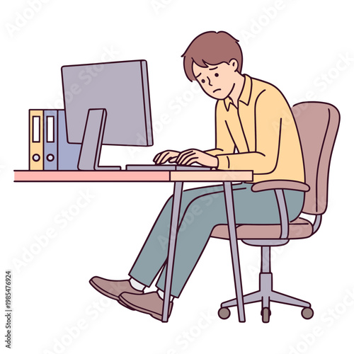 A man sitting at a desk working on a computer with binders nearby indoors.