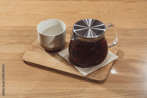 Glass teapot with herbal fruit tea on board