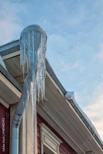 Ice hangs from a gutter, sharp and heavy