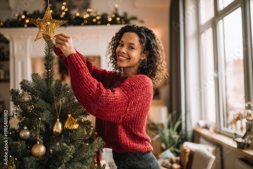 Woman decorating Christmas tree with festive ornaments