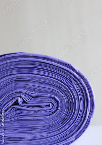 Vertical image of circular pattern of tightly folded layers in a roll of trash bags 