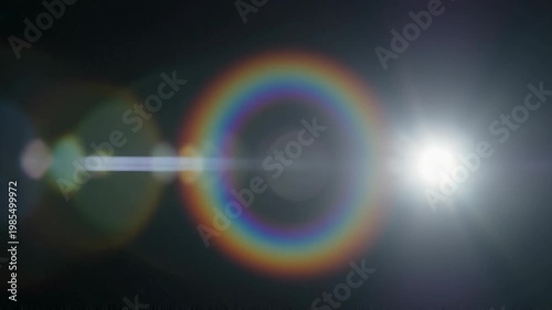 Elegant lens flare on black backdrop concept. Bright sun with colorful halo and lens flare effect in dark sky