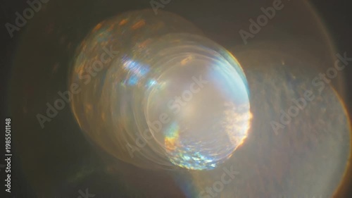 Elegant lens flare on black backdrop concept. Abstract glowing light reflections with soft bokeh effect and radiant circular patterns
