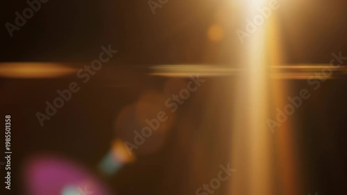 Elegant lens flare on black backdrop concept. Abstract golden light beams with lens flare effect on dark background for creative design