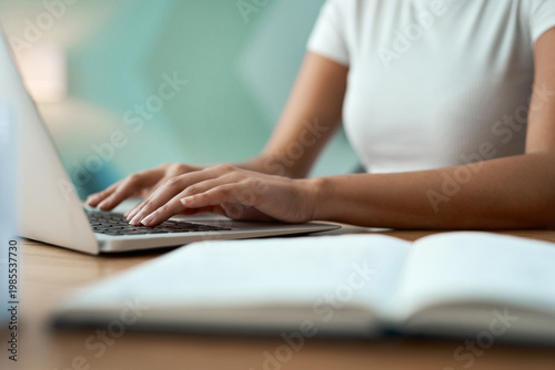 Fotografie Typing, hands and woman with laptop at desk, online course essay and studying for college assessment