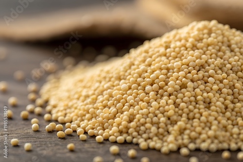 Amaranth Month A pile of millet grains on a wooden surface with a blurred background