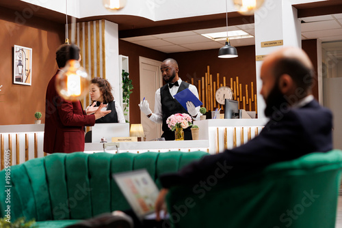 Foto Bellhop filling in registration files for businessman arriving at hotel resort, receiving luxury concierge services