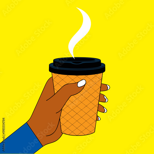 Hand holding steaming coffee cup against bright yellow background  