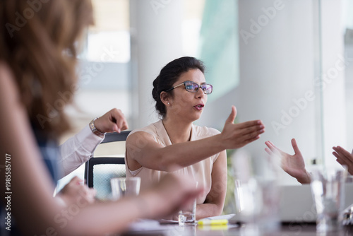 Vászonkép Businesswoman leading a heated team discussion in a modern office meeting room w