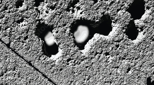 Abstract textured surface with dark craters and light highlights