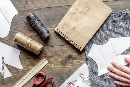 desktop designer clothes with tools top view at wooden table