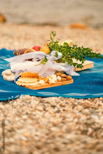 outdoor picnic breakfast with croissant and fresh fruit on blue blanket