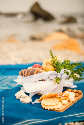 picnic with fresh fruit and croissant on blue blanket