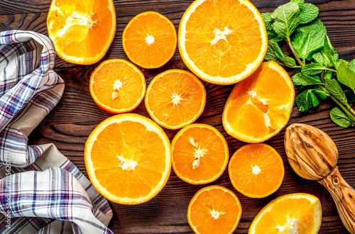 Fresh oranges in slices with mint leaves on kitchen top view