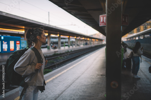 Side view of woman with backpack at train station