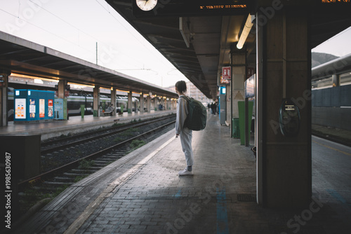 Solo traveler with backpack at railway station