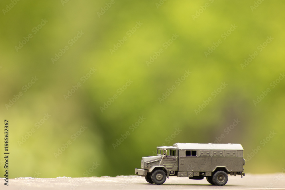 Fototapeta premium Miniature Military Transport Truck – Toy Army Vehicle in Natural Outdoor Setting
