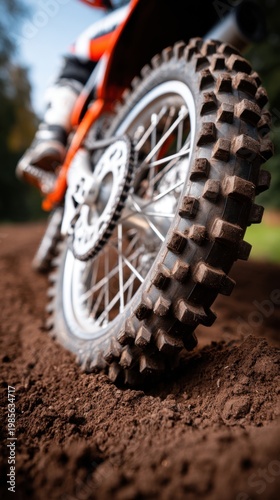Motocross athlete speeding off road, dirt bike wheel spinning on dusty track, showcasing extreme sport performance, off road racing, and powerful motocross action