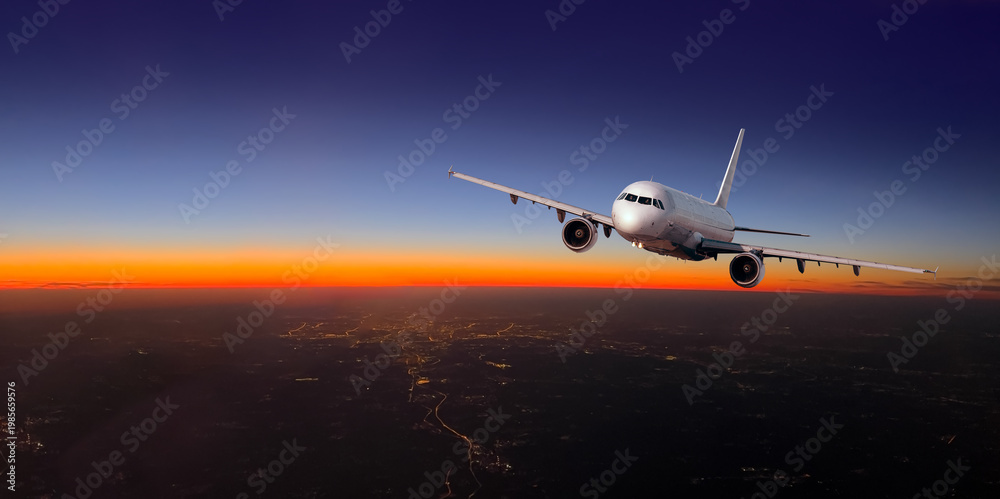 Naklejka premium Airplane flying over city lights during sunset travel