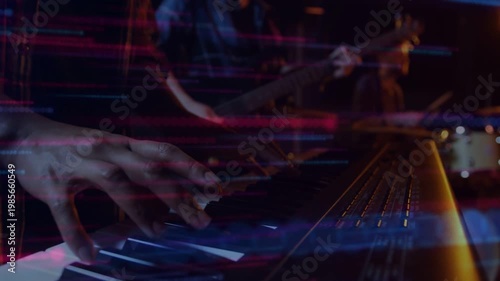 Band starting rhythm, woman playing keys speeding runs to build song as neon streaks intensifying