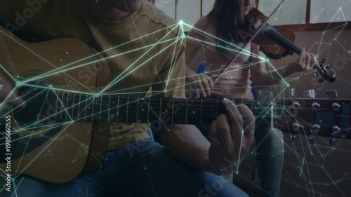 Guitarist playing while camera zooming out to reveal violinist rehearsing music, overlay on strings