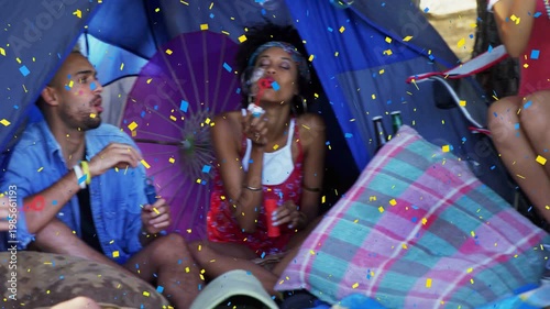 Vertical video: group in camp tent raising wands blowing bubbles relaxing, panning showing confetti