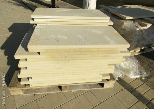 stone tiles for facing the facade of the building are stacked on a wooden pallet. building materials. natural stone is a high-quality and durable material. care for the environment
