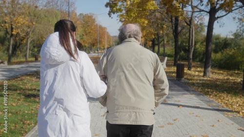 Compassionate nursing care, back view of elderly man and caregiver