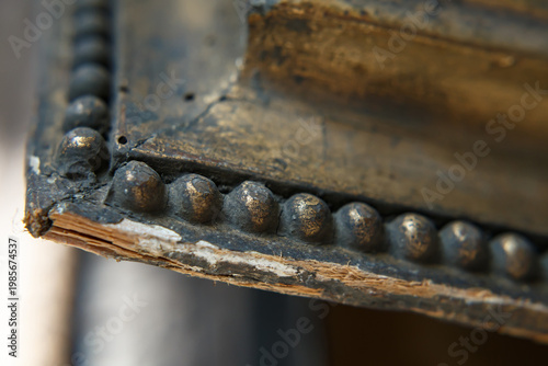 Close View of an Old Wooden Frame With Metal Detailing Showing Wear and Age From Years of Use in a Historical Setting