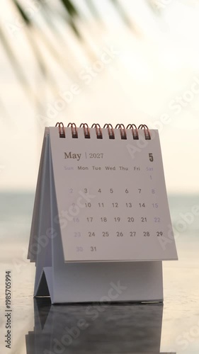 A close-up view of a hand flipping a calendar page from April to May 2027, symbolizing planning for the upcoming month and monthly strategic goal setting. Vertical, 4K resolution.