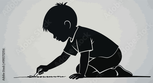 Silhouette of a child kneeling and drawing on the floor with a crayon or chalk on gray background