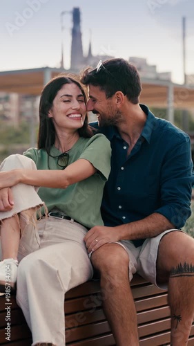Video of beautiful couple posing and looking at camera while sitting on a bench in the city