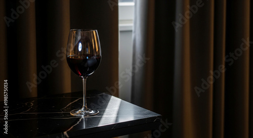 Elegant glass of red wine on modern table with soft natural lighting