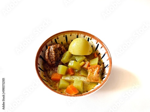 Hearty stew sits in a rustic bowl