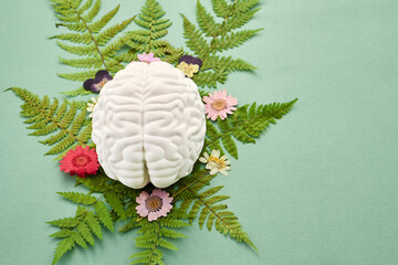 Mental Health Awareness Month. Brain on fern and flowers symbolizing mental wellness