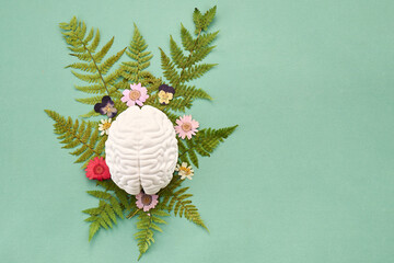 Mental Health Awareness Month. Brain model surrounded by fern leaves and flowers