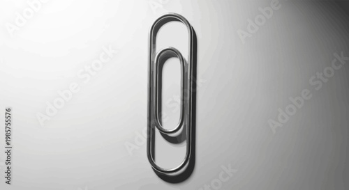 Closeup of single large metal paperclip.