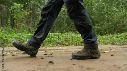 Hiker walking on wet muddy forest path after rainfall