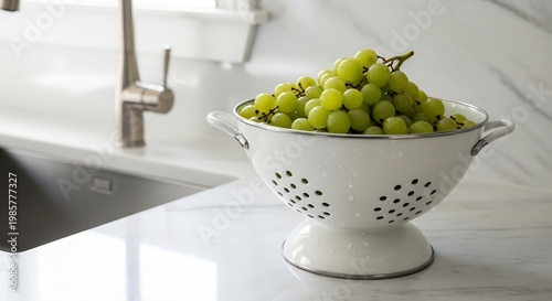 Fresh Green Grapes in a White Colander on a Kitchen Countertop.